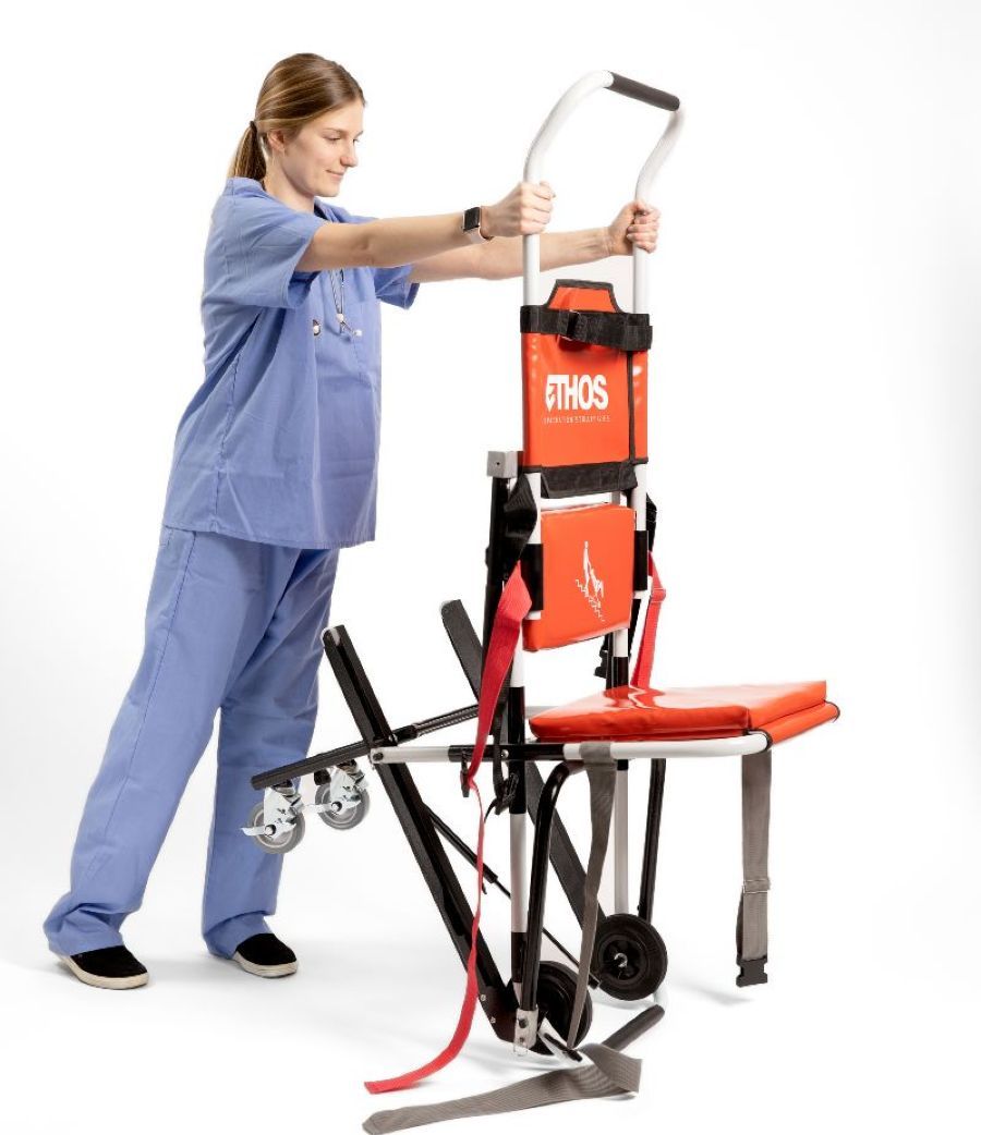 Female clinician unfolding red chair with wheels.