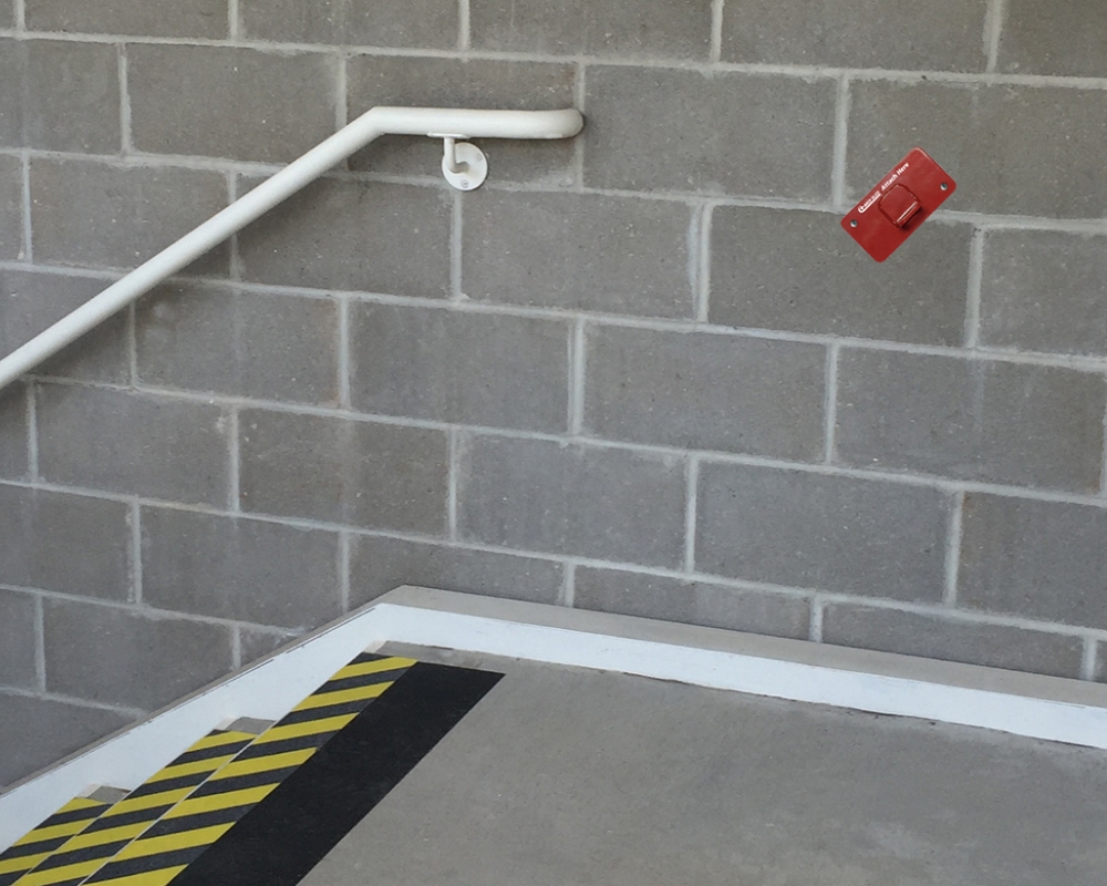 Red metal bracket and bolts for attaching to concrete wall
