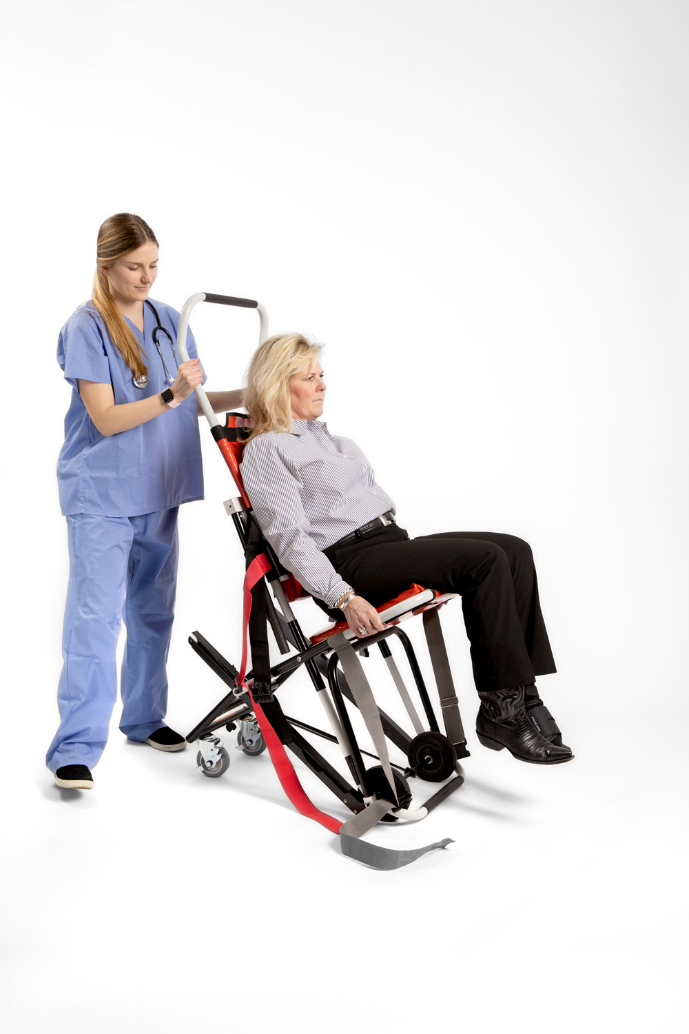 Nurse behind evacuation chair with woman sitting. 